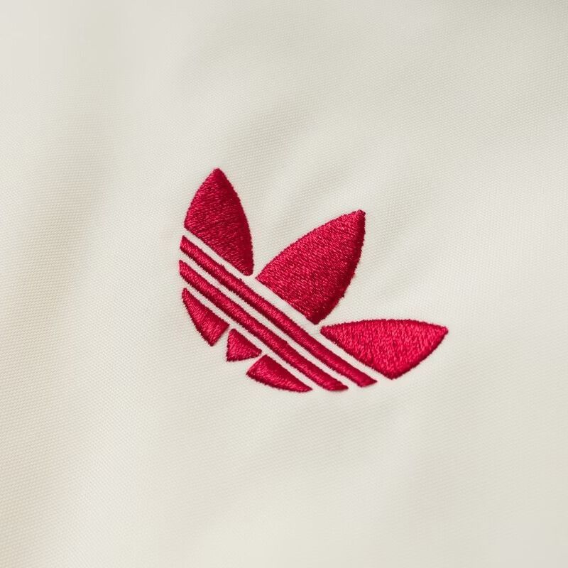 לוגו Trefoil רקום באדום על ז׳קט adidas אוף-וייט, תקריב